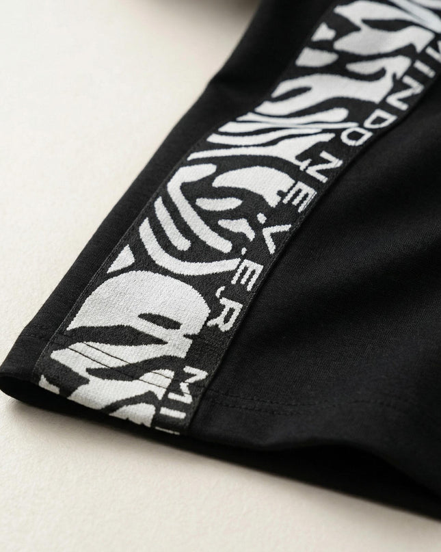 Κοντινή λεπτομέρεια της διακοσμητικής ρίγας με σχέδιο στο τελείωμα από το μαύρο σπορ κομψό φόρεμα μεγάλα μεγέθη.