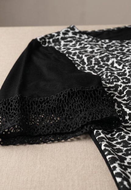 Κοντινή λεπτομέρεια σε μαύρη βαμβακερή μάξι τουνίκ plus size, που αναδεικνύει το κοντό μανίκι με τελείωμα από δίχτυ και το ασπρόμαυρο μοτίβο.