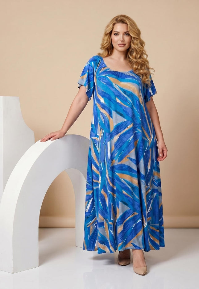 Ολόσωμη λήψη. Μπλε επίσημο μάξι φόρεμα plus size με εντυπωσιακό αφηρημένο μοτίβο, αέρινη εφαρμογή και κοντά μανίκια τύπου πεταλούδα.