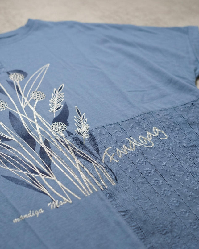 Κοντινή λεπτομέρεια στην μπλε καλοκαιρινή τουνίκ μεγάλα μεγέθη, που αναδεικνύει το κεντημένο φλοράλ σχέδιο και την κομψή υφή της δαντέλας.