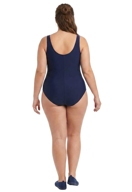 Πίσω όψη από σκούρο μπλε ολόσωμο μαγιό plus size, με ανοιχτή πλάτη σε σχήμα U και φαρδιές τιράντες. Φωτογράφιση σε λευκό φόντο.