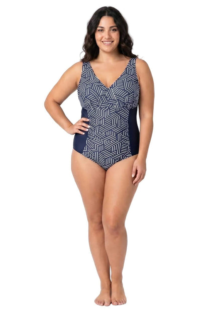 Ολόσωμη λήψη σε λευκό φόντο. Ολόσωμο μαγιό plus size σε ναυτικό μπλε με λευκό γεωμετρικό μοτίβο στο μπροστινό μέρος και μονόχρωμα σκούρα πλαϊνά.