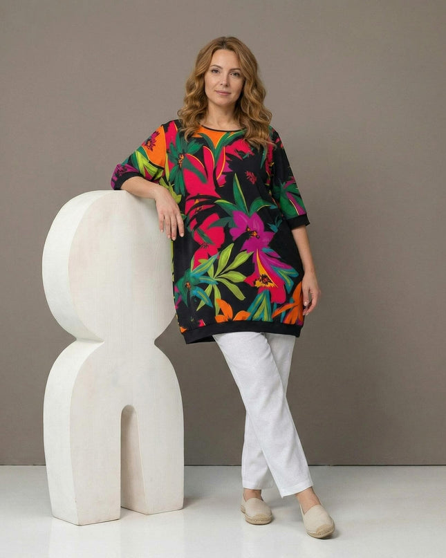 Ολόσωμη λήψη: Πολύχρωμη καλοκαιρινή τουνίκ σε μεγάλα μεγέθη, με έντονο τροπικό φλοράλ σχέδιο σε μαύρο φόντο και κοντά μανίκια.