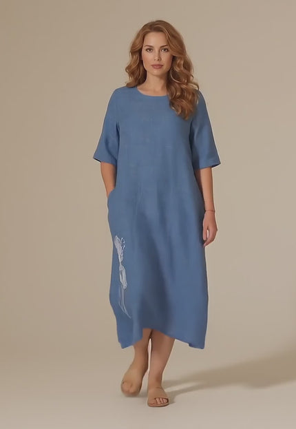 Γυναικείο plus size μοντέλο περπατάει αργά προς την κάμερα μέσα σε στούντιο με ουδέτερο φόντο φορώντας το Καθημερινό βαμβακερό μάξι φόρεμα μεγάλα μεγέθη σε μπλε χρώμα