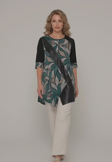 Ένα plus size μοντέλο περπατά αργά προς την κάμερα σε ένα περιβάλλον στούντιο με ουδέτερο φόντο φορώντας το προϊόν Επίσημη plus size μάξι τουνίκ με ασύμμετρη γραμμή και οικολογικό δέρμα