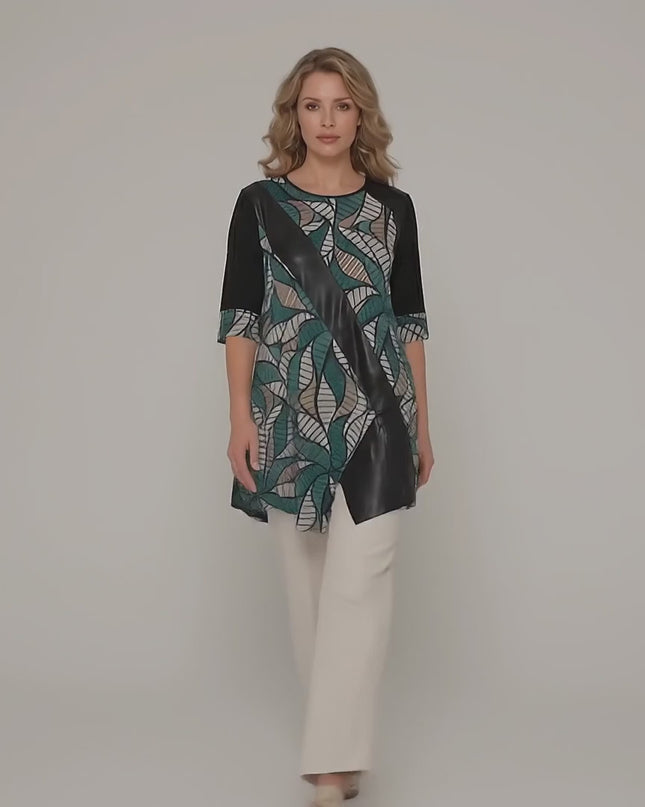 Ένα plus size μοντέλο περπατά αργά προς την κάμερα σε ένα περιβάλλον στούντιο με ουδέτερο φόντο φορώντας το προϊόν Επίσημη plus size μάξι τουνίκ με ασύμμετρη γραμμή και οικολογικό δέρμα