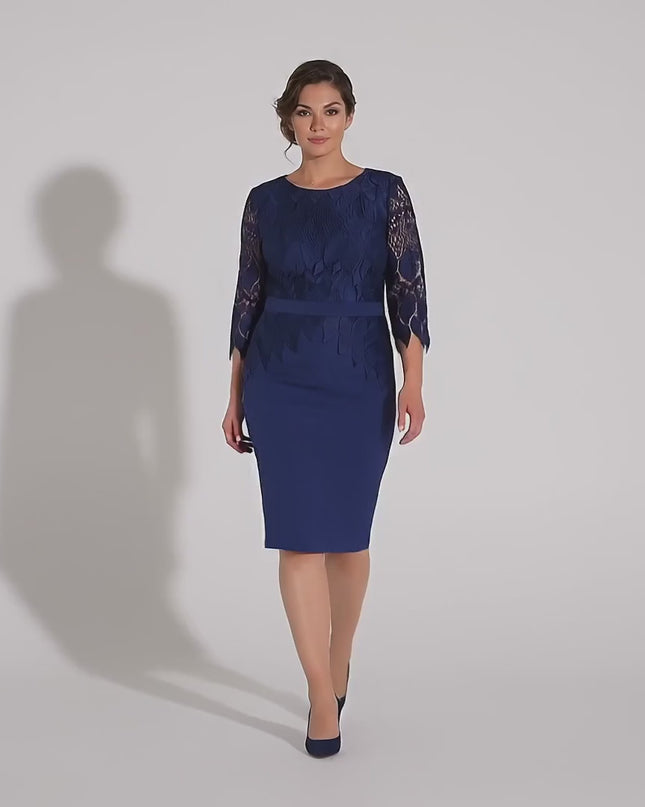 Βίντεο παρουσίασης σε περιβάλλον στούντιο όπου ένα plus-size μοντέλο περπατάει αργά προς την κάμερα φορώντας το Επίσημο μπλε σκούρο φόρεμα με δαντέλα και ζώνη σε μεγάλα μεγέθη