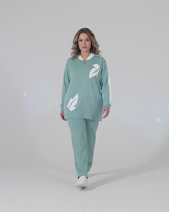 Βίντεο παρουσίασης σε στούντιο όπου ένα μοντέλο περπατάει αργά προς την κάμερα φορώντας το Γυναικείο plus size σετ δύο τεμαχίων σε ανοιχτό πράσινο με λεπτομέρειες οικολογικού δέρματος