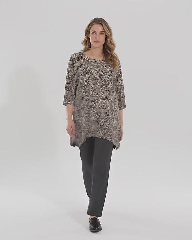 Βίντεο παρουσίασης σε περιβάλλον στούντιο με ουδέτερο φόντο όπου ένα γυναικείο μοντέλο περπατάει αργά προς την κάμερα φορώντας το προϊόν Καθημερινή μάξι τουνίκα μεγάλα μεγέθη με λεοπάρ σχέδιο και σκισίματα