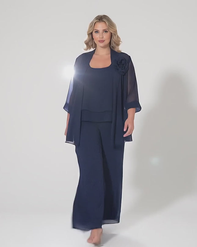 Ένα plus-size μοντέλο περπατάει αργά προς την κάμερα σε ένα στούντιο με ουδέτερο φόντο φορώντας το προϊόν Κομψό Επίσημο Σετ Τριών Τεμαχίων Σκούρο Μπλε Μεγάλα Μεγέθη