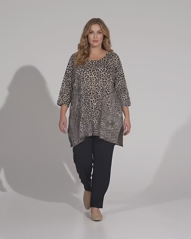 Βίντεο σε περιβάλλον στούντιο όπου ένα μοντέλο περπατάει αργά προς την κάμερα φορώντας το προϊόν Καθημερινή μάξι λεοπάρ τουνίκ σε μεγάλα μεγέθη