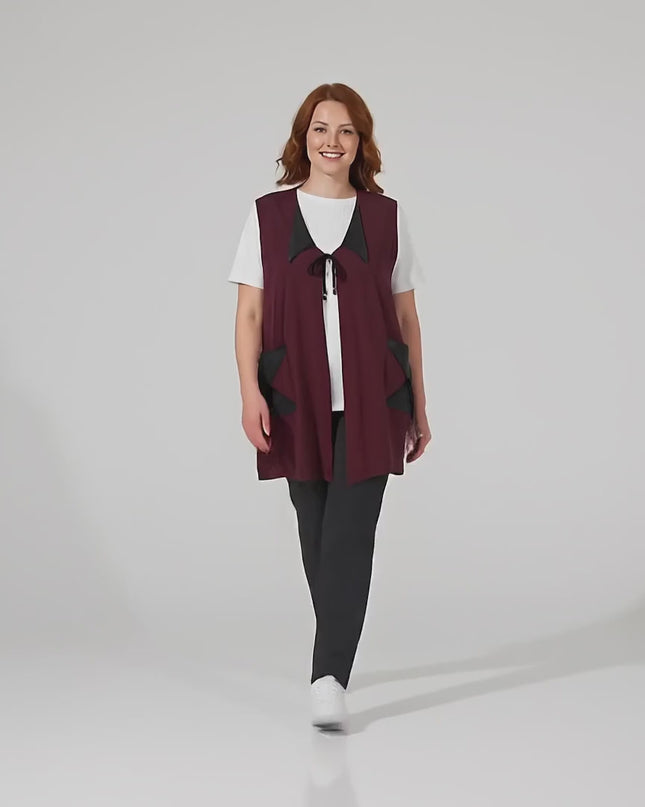 Βίντεο παρουσίασης σε στούντιο με ουδέτερο φόντο όπου ένα plus-size γυναικείο μοντέλο περπατάει αργά προς την κάμερα φορώντας το προϊόν Εβαζέ μπορντό γιλέκο με λεπτομέρειες δερματίνης μεγάλα μεγέθη