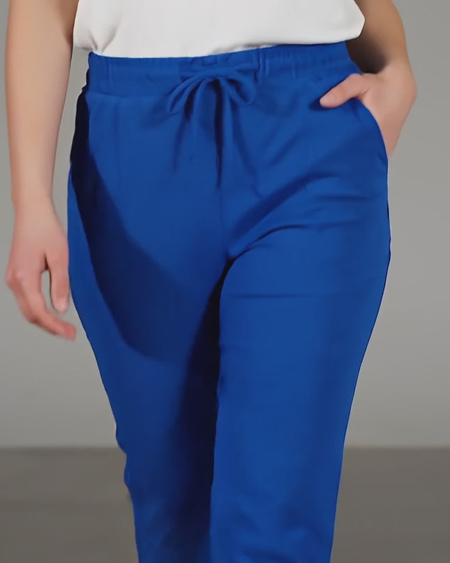 Βίντεο παρουσίασης σε στούντιο όπου ένα plus-size μοντέλο περπατάει αργά προς την κάμερα φορώντας το προϊόν Γυναικείο παντελόνι ρουά με λάστιχο και κορδόνια σε μεγάλα μεγέθη