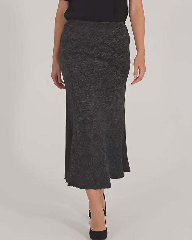 Ένα γυναικείο plus-size μοντέλο περπατάει αργά προς την κάμερα σε περιβάλλον στούντιο με ουδέτερο φόντο, φορώντας το προϊόν Φούστα Σκούρο Γκρι - Μεγάλα Μεγέθη - Λάστιχο στη Μέση - Άνετη Μέχρι τον Αστράγαλο - Φθινόπωρο-Χειμώνας