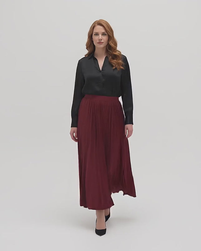 Βίντεο παρουσίασης σε στούντιο με ουδέτερο φόντο όπου ένα plus size γυναικείο μοντέλο περπατάει αργά προς την κάμερα φορώντας το προϊόν Επίσημη μπορντό εβαζέ φούστα σε μεγάλα μεγέθη