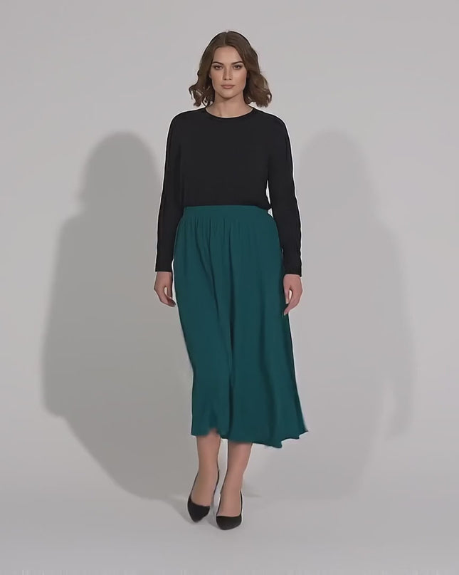 Βίντεο παρουσίασης σε στούντιο όπου ένα μοντέλο περπατάει αργά προς την κάμερα φορώντας το προϊόν Λαδί επίσημη γυναικεία κλος φούστα σε μεγάλα μεγέθη