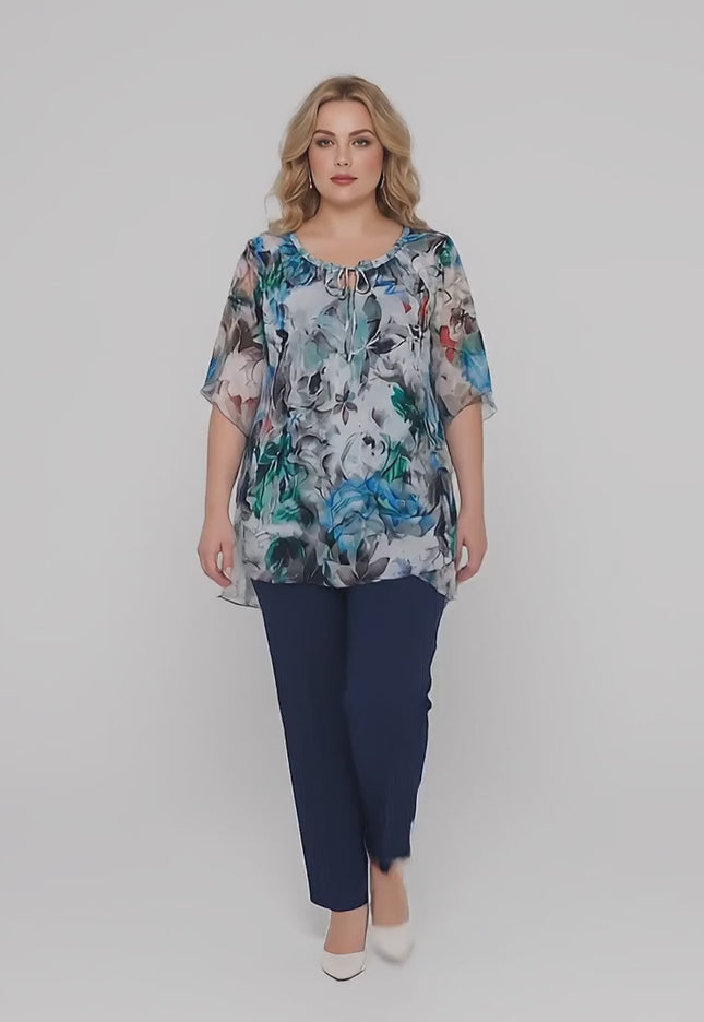 Σε περιβάλλον στούντιο ένα plus-size γυναικείο μοντέλο περπατάει αργά προς την κάμερα φορώντας την Κομψή επίσημη γυναικεία τουνίκ σε μεγάλα μεγέθη