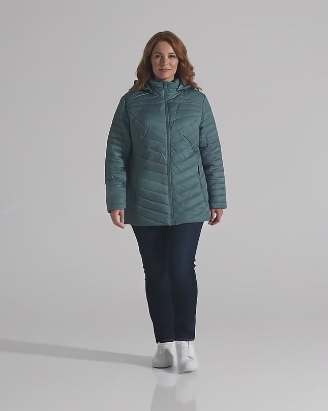 Βίντεο παρουσίασης σε στούντιο με ουδέτερο φόντο όπου ένα μοντέλο περπατάει αργά προς την κάμερα φορώντας το Πράσινο γυναικείο μπουφάν plus size με αποσπώμενη κουκούλα και εβαζέ γραμμή