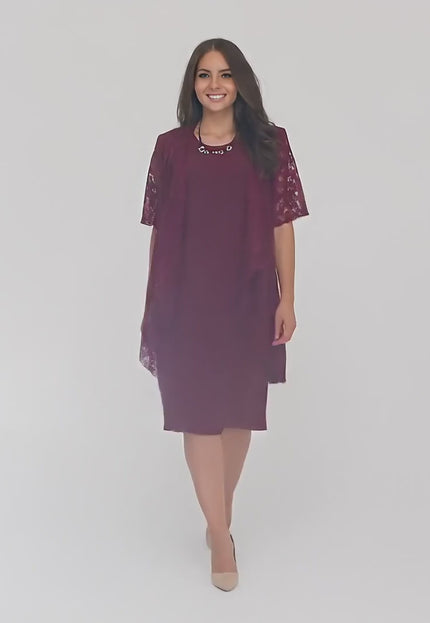 Ένα plus-size μοντέλο περπατάει αργά προς την κάμερα σε περιβάλλον στούντιο με ουδέτερο φόντο, φορώντας το Σετ φόρεμα με δαντελένιο ζακετάκι σε μπορντό- Άνοιξη-Καλοκαίρι