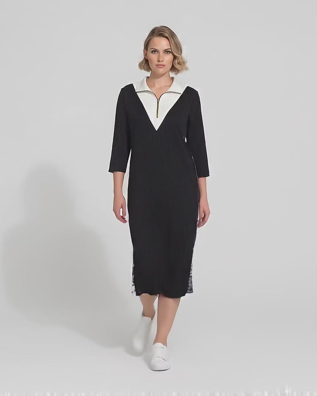 Ένα plus-size μοντέλο περπατάει αργά προς την κάμερα σε περιβάλλον στούντιο με ουδέτερο φόντο φορώντας το προϊόν Μαύρο σπορ κομψό φόρεμα με φερμουάρ και πλαϊνές ρίγες μεγάλα μεγέθη