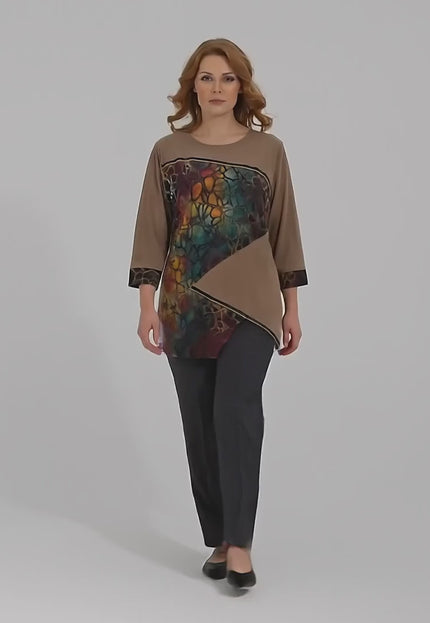 Ένα plus size μοντέλο περπατάει αργά προς την κάμερα σε ένα στούντιο με ουδέτερο φόντο φορώντας Επίσημη καφέ τουνίκ σε ριχτή γραμμή με ασύμμετρη εμπριμέ φάσα