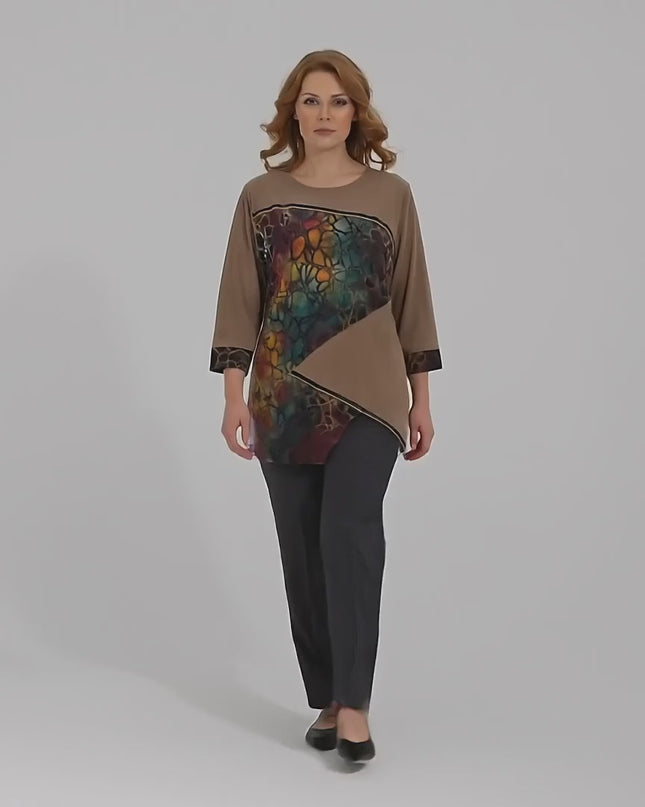 Ένα plus size μοντέλο περπατάει αργά προς την κάμερα σε ένα στούντιο με ουδέτερο φόντο φορώντας Επίσημη καφέ τουνίκ σε ριχτή γραμμή με ασύμμετρη εμπριμέ φάσα
