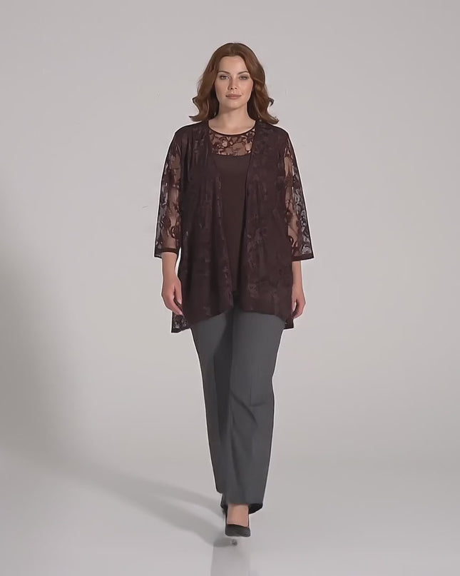 Ένα μοντέλο σε περιβάλλον στούντιο με ουδέτερο φόντο περπατάει αργά προς την κάμερα φορώντας το προϊόν Επίσημο καφέ γυναικείο σετ δύο τεμαχίων με δαντέλα plus size