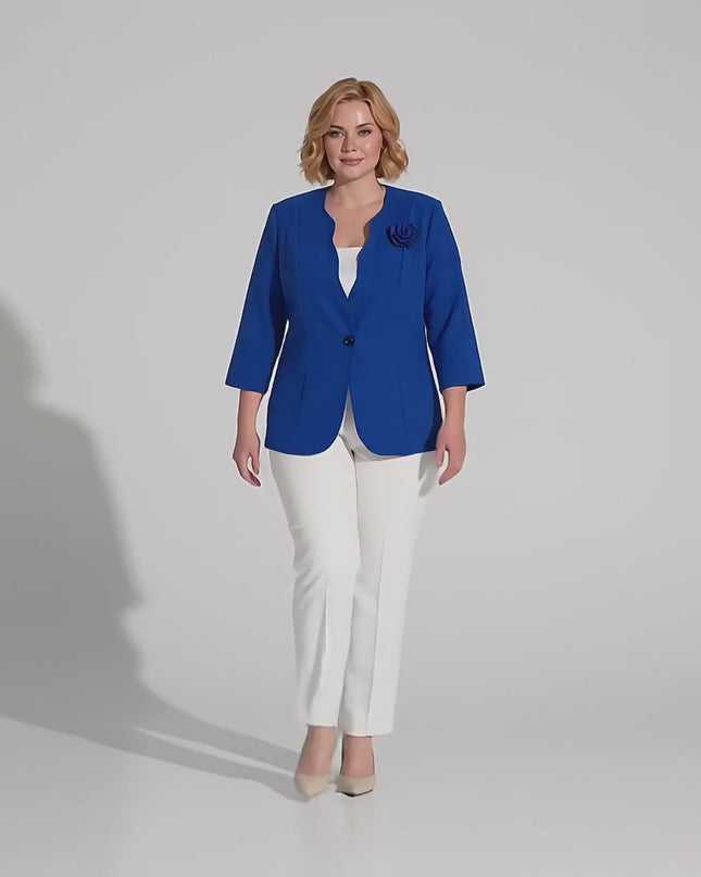 Βίντεο παρουσίασης σε περιβάλλον στούντιο με ουδέτερο φόντο, όπου ένα plus-size γυναικείο μοντέλο περπατάει αργά προς την κάμερα φορώντας το Επίσημο γυναικείο σακάκι μεγάλα μεγέθη μπλε ρουά με τριαντάφυλλο