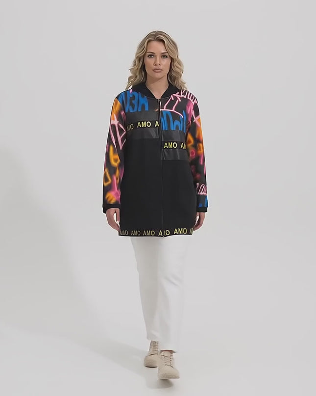 Ένα plus-size μοντέλο περπατάει αργά προς την κάμερα σε περιβάλλον στούντιο με ουδέτερο φόντο, φορώντας το προϊόν Μαύρη γυναικεία ζακέτα plus size με κουκούλα και τύπωμα