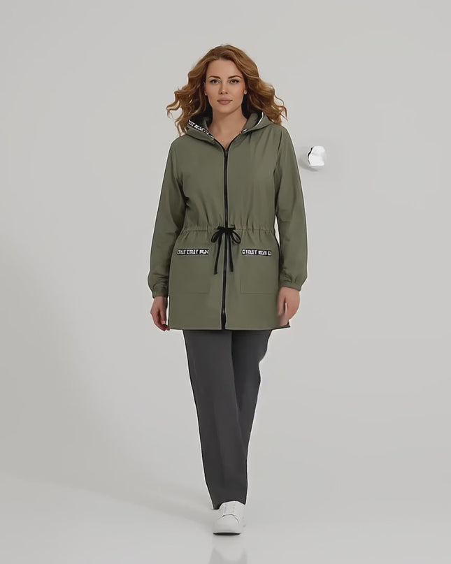 Βίντεο παρουσίασης σε περιβάλλον στούντιο όπου ένα μοντέλο περπατάει αργά προς την κάμερα φορώντας το προϊόν Γυναικεία ζακέτα χακί μεγάλα μεγέθη με κουκούλα και κορδόνια στη μέση