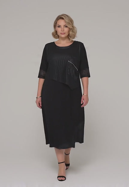 Βίντεο παρουσίασης σε στούντιο με ουδέτερο φόντο όπου ένα μοντέλο περπατάει αργά προς την κάμερα φορώντας το Κομψό μαύρο μάξι επίσημο φόρεμα μεγάλα μεγέθη με δίχτυ