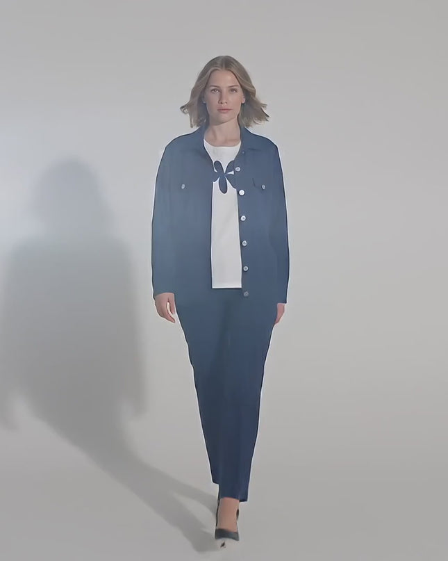 Ένα plus-size γυναικείο μοντέλο περπατάει αργά προς την κάμερα σε περιβάλλον στούντιο με ουδέτερο φόντο φορώντας το προϊόν Επίσημο γυναικείο σετ σακάκι και t-shirt μεγάλα μεγέθη σε μπλε