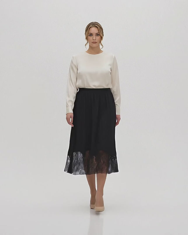 Παρουσίαση σε περιβάλλον στούντιο με ουδέτερο φόντο όπου ένα plus-size γυναικείο μοντέλο περπατάει αργά προς την κάμερα φορώντας την Επίσημη μαύρη μάξι φούστα με δαντέλα σε μεγάλα μεγέθη