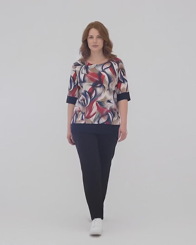 Ένα plus size μοντέλο περπατάει αργά προς την κάμερα σε περιβάλλον στούντιο με ουδέτερο φόντο φορώντας το προϊόν Σκούρο μπλε καθημερινό σετ τουνίκ με παντελόνι plus size