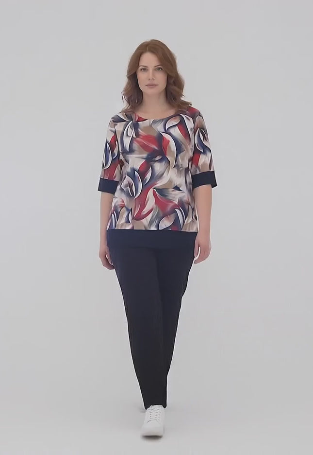Ένα plus size μοντέλο περπατάει αργά προς την κάμερα σε περιβάλλον στούντιο με ουδέτερο φόντο φορώντας το προϊόν Σκούρο μπλε καθημερινό σετ τουνίκ με παντελόνι plus size