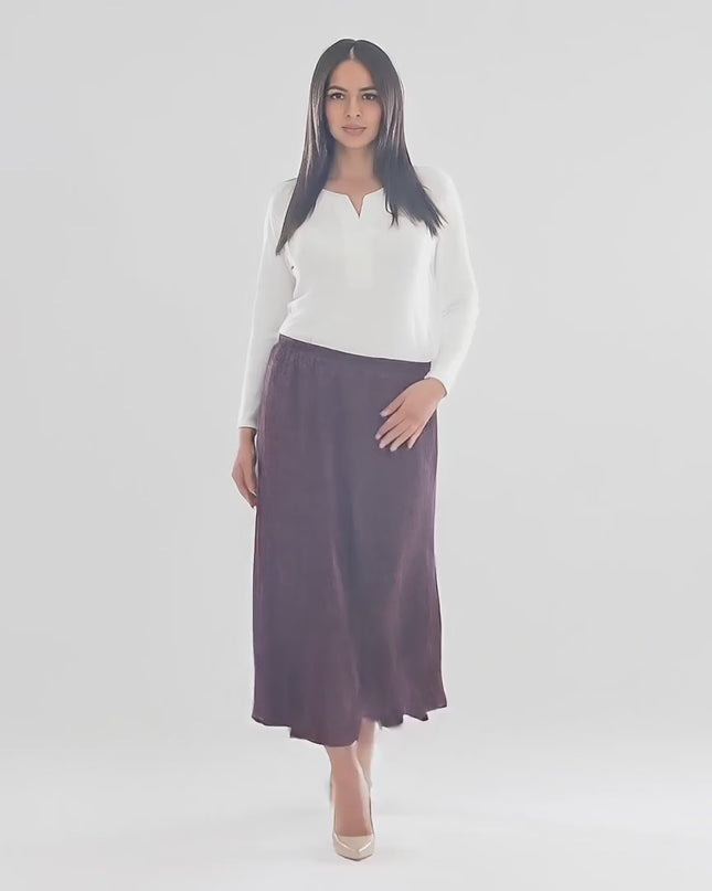 Βίντεο παρουσίασης σε περιβάλλον στούντιο με ουδέτερο φόντο όπου ένα plus size μοντέλο περπατάει αργά προς την κάμερα φορώντας το προϊόν Χειμερινή Μάξι Φούστα Μπορντό – Μεγάλα Μεγέθη