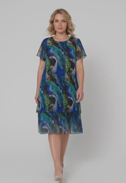 Γυναικείο μοντέλο plus size περπατάει αργά προς την κάμερα σε περιβάλλον στούντιο με ουδέτερο φόντο φορώντας το προϊόν Επίσημο σιφόν φόρεμα σε ντεγκραντέ αποχρώσεις μεγάλα μεγέθη