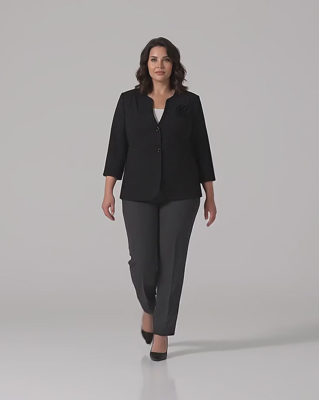 Βίντεο παρουσίασης σε περιβάλλον στούντιο όπου ένα μοντέλο περπατάει αργά προς την κάμερα φορώντας το προϊόν Κομψό μαύρο γυναικείο σακάκι plus size με λεπτομέρεια τριαντάφυλλο