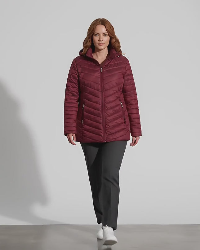 Ένα plus-size μοντέλο σε περιβάλλον στούντιο με ουδέτερο φόντο περπατάει αργά προς την κάμερα φορώντας το προϊόν Μπορντό χειμερινό μπουφάν εβαζέ σε μεγάλα μεγέθη με αποσπώμενη κουκούλα