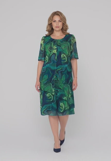 Βίντεο παρουσίασης σε στούντιο με ουδέτερο φόντο όπου ένα γυναικείο μοντέλο περπατάει αργά προς την κάμερα φορώντας το Σκούρο μπλε επίσημο φόρεμα μεγάλα μεγέθη με ασύμμετρο σιφόν