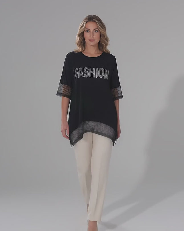 Βίντεο παρουσίασης σε περιβάλλον στούντιο με ουδέτερο φόντο όπου ένα μοντέλο περπατάει αργά προς την κάμερα φορώντας το προϊόν Κομψή μαύρη ασύμμετρη τουνίκ plus size με δίχτυ και στρας