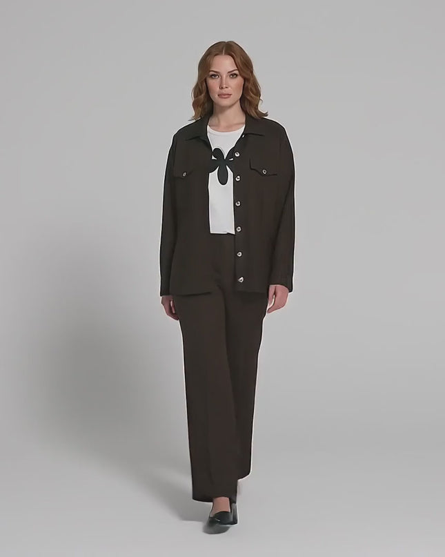 Βίντεο σε περιβάλλον στούντιο με ένα μοντέλο να περπατάει αργά προς την κάμερα φορώντας το Επίσημο καφέ plus size σετ δύο τεμαχίων με φλοράλ μοτίβο