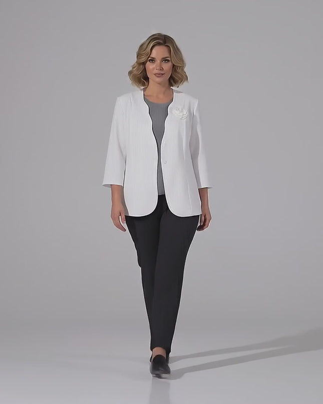 Βίντεο παρουσίασης σε περιβάλλον στούντιο με ουδέτερο φόντο όπου ένα plus size μοντέλο περπατάει αργά προς την κάμερα φορώντας το προϊόν Επίσημο λευκό σακάκι σε μεγάλα μεγέθη με καρφίτσα τριαντάφυλλο