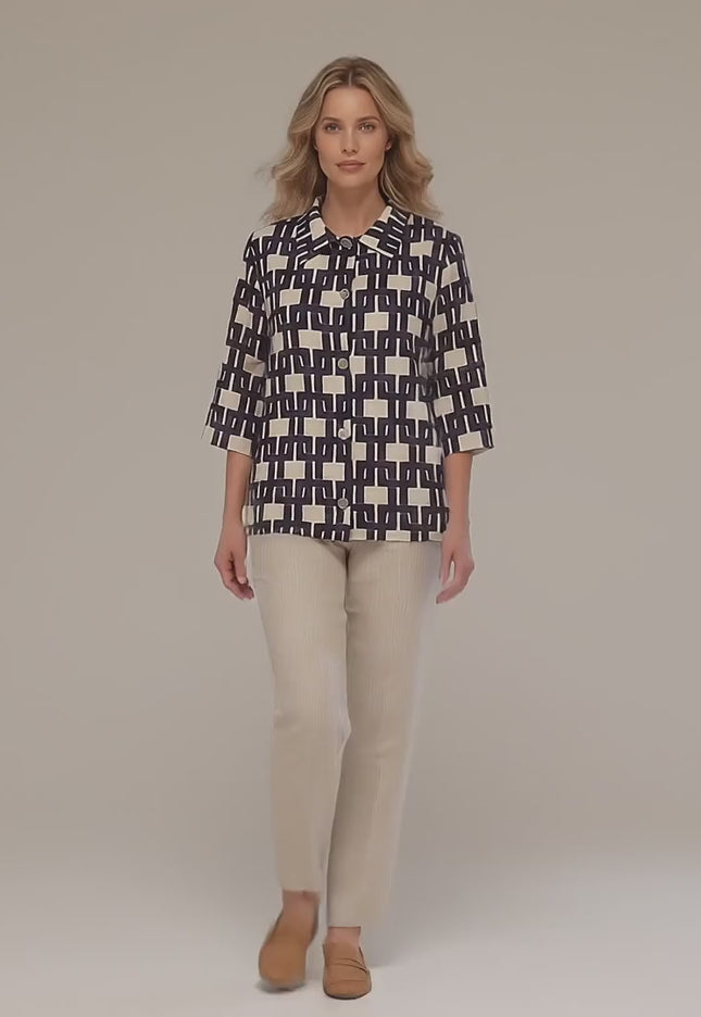 Ένα plus size μοντέλο περπατάει αργά προς την κάμερα σε περιβάλλον στούντιο φορώντας το προϊόν Επίσημο γυναικείο πουκάμισο σε άνετη γραμμή με γεωμετρικό σχέδιο