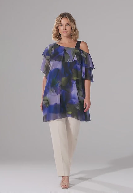 Ένα plus size μοντέλο περπατάει αργά προς την κάμερα σε περιβάλλον στούντιο με ουδέτερο φόντο φορώντας το προϊόν Επίσημη ασύμμετρη τουνίκ σιφόν με ντεγκραντέ τύπωμα