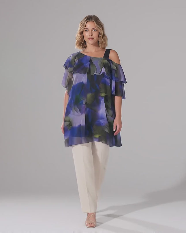 Ένα plus size μοντέλο περπατάει αργά προς την κάμερα σε περιβάλλον στούντιο με ουδέτερο φόντο φορώντας το προϊόν Επίσημη ασύμμετρη τουνίκ σιφόν με ντεγκραντέ τύπωμα