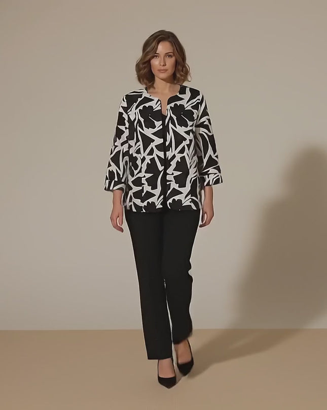 Βίντεο παρουσίασης σε περιβάλλον στούντιο όπου ένα plus size μοντέλο περπατάει αργά προς την κάμερα φορώντας το προϊόν Κομψό ασπρόμαυρο γυναικείο σακάκι χωρίς κούμπωμα σε μεγάλα μεγέθη