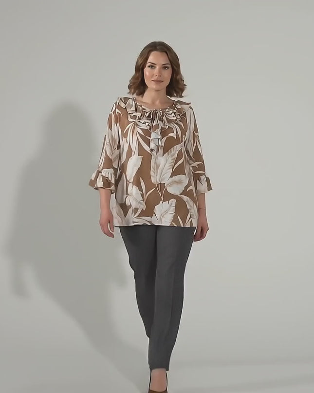 Βίντεο παρουσίασης σε περιβάλλον στούντιο όπου ένα plus-size μοντέλο περπατάει αργά προς την κάμερα φορώντας το προϊόν Επίσημη εβαζέ τουνίκ σε ανοιχτό καφέ μεγάλα μεγέθη