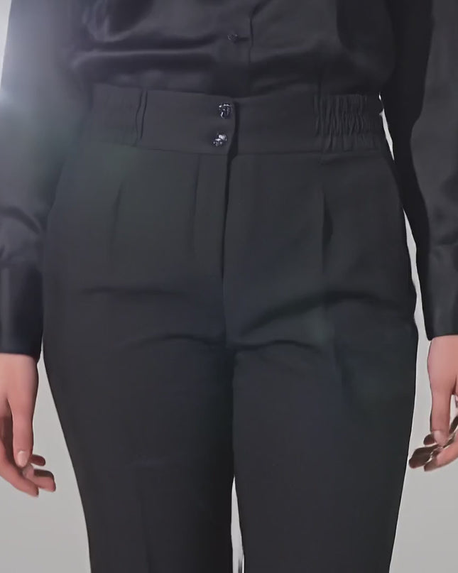 Βίντεο παρουσίασης σε στούντιο με ουδέτερο φόντο όπου ένα μοντέλο περπατάει αργά προς την κάμερα φορώντας το προϊόν Επίσημο μαύρο γυναικείο παντελόνι σε ίσια γραμμή plus size