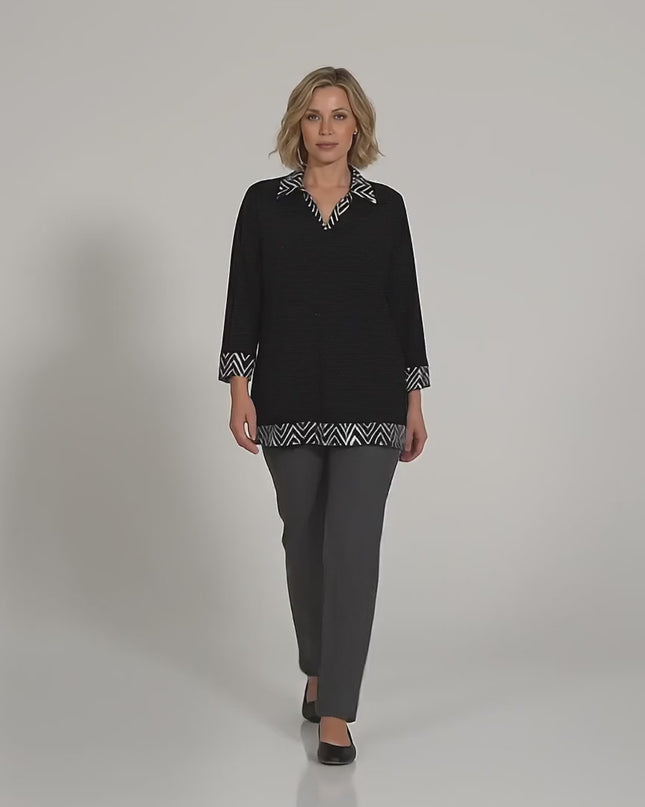 Βίντεο παρουσίασης σε περιβάλλον στούντιο όπου ένα γυναικείο μοντέλο περπατάει αργά προς την κάμερα φορώντας το προϊόν Επίσημη μαύρη τουνίκ με γιακά και μανσέτες plus size